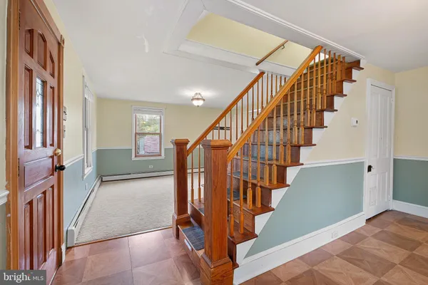 a view of staircase with lots of frames on wall and windows