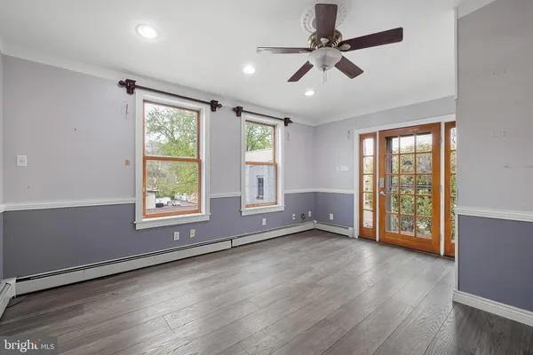 a view of an empty room with a window and wooden floor