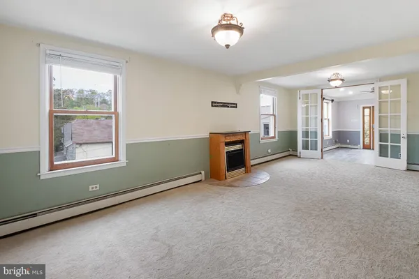 an empty room with fireplace and windows