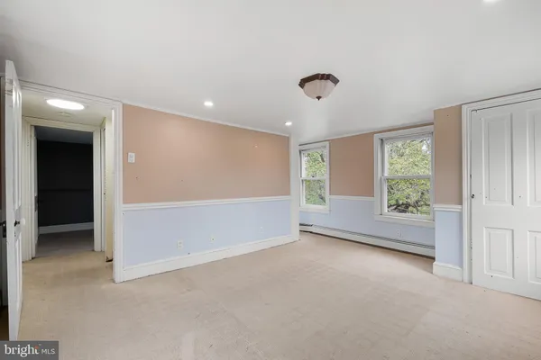 an empty room with windows and closet