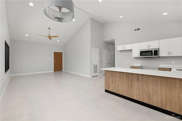 a view of a kitchen with stainless steel appliances a refrigerator oven a sink dishwasher with a dining table and chairs