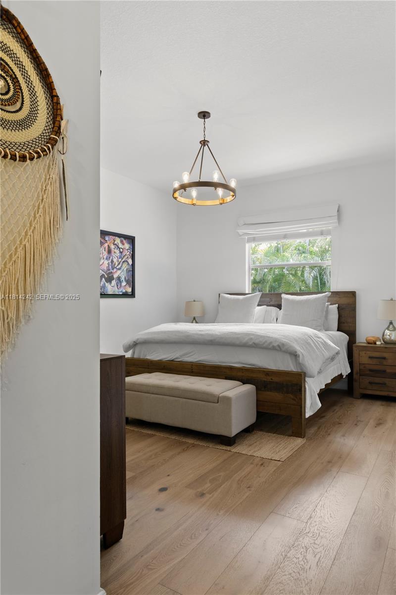 9339 Southwest 98th Place Miami, FL 33176 - Photo 32 of 33 a bedroom with a bed and a chandelier