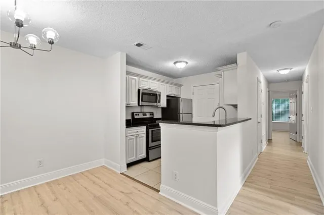 a kitchen with stainless steel appliances granite countertop a sink stove and cabinets