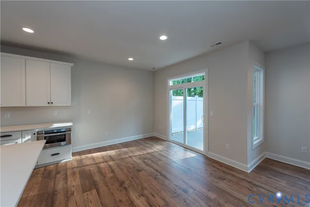 a view of a kitchen with wooden floor and electronic appliances