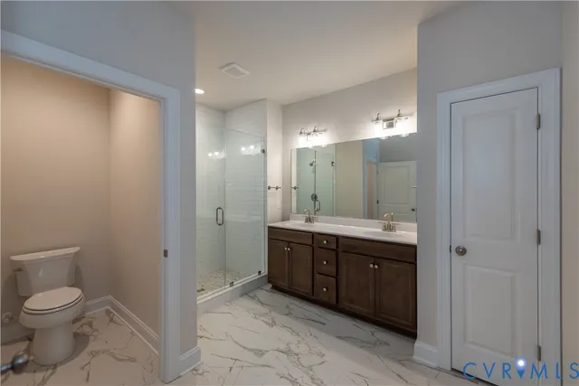 a spacious bathroom with a granite countertop sink a toilet and a mirror