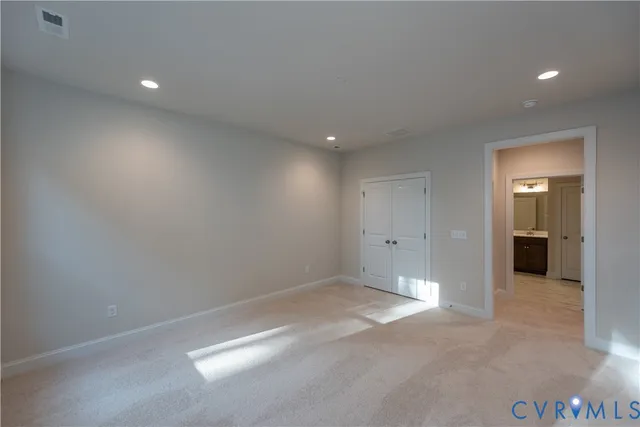 an empty room with closet and a bathroom