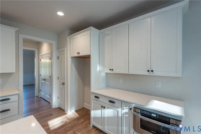 a kitchen with white cabinets and stainless steel appliances