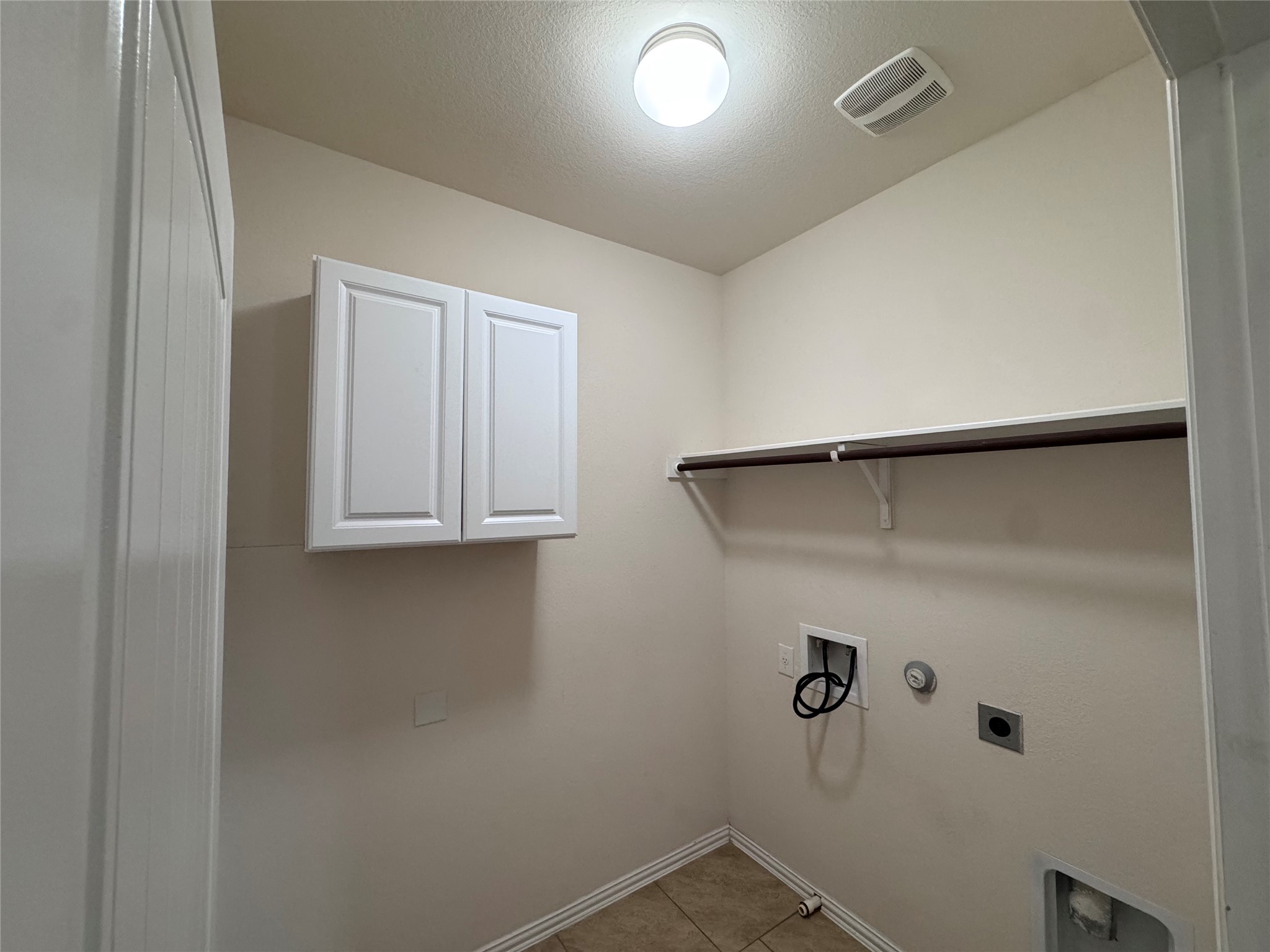 2605 Rough Berry Road Pflugerville, TX 78660 - Photo 28 of 40 Functional laundry space with convenient shelving and a mounted cabinet for storage.