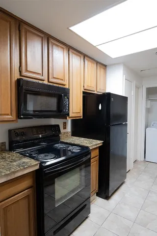 a kitchen with granite countertop a refrigerator stove and microwave