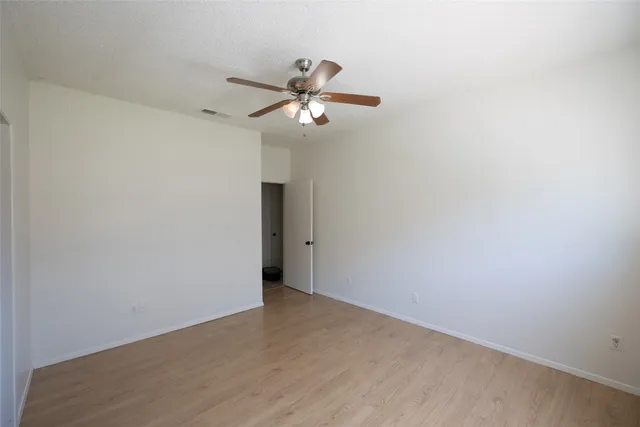 a view of a small space with wooden floor and a ceiling fan