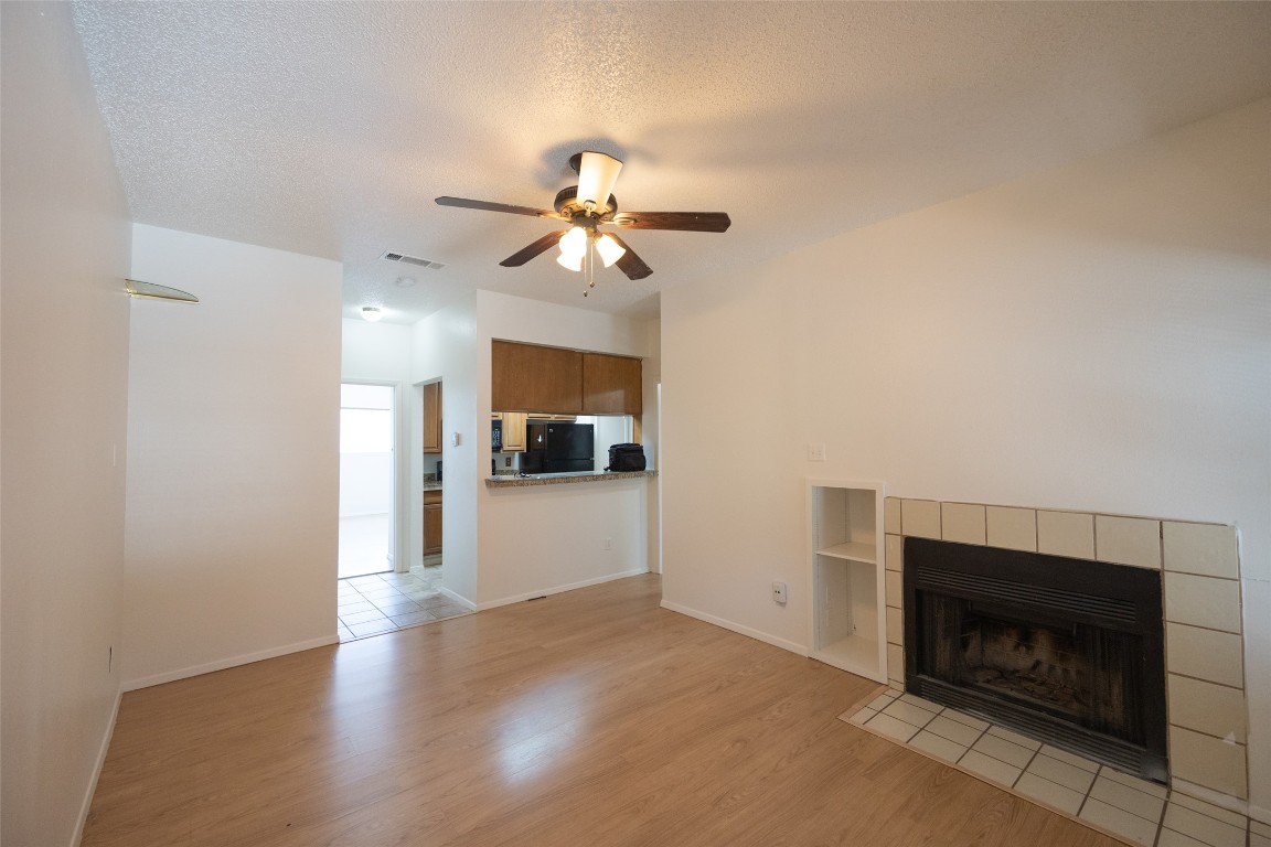 806 West 24th Street, Unit 207 Austin, TX 78705 - Photo 6 of 8 a view of a kitchen and an empty room with a fireplace