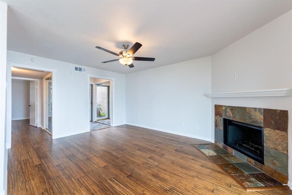 4610 Chaha Road, Unit 106 Garland, TX 75043 - Photo 9 of 25 wooden floor in an empty room with a fireplace