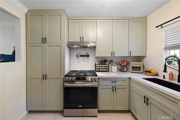 a kitchen with a stove and white cabinets