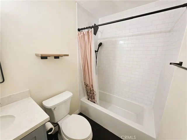 a white toilet sitting next to a bath tub and a shower