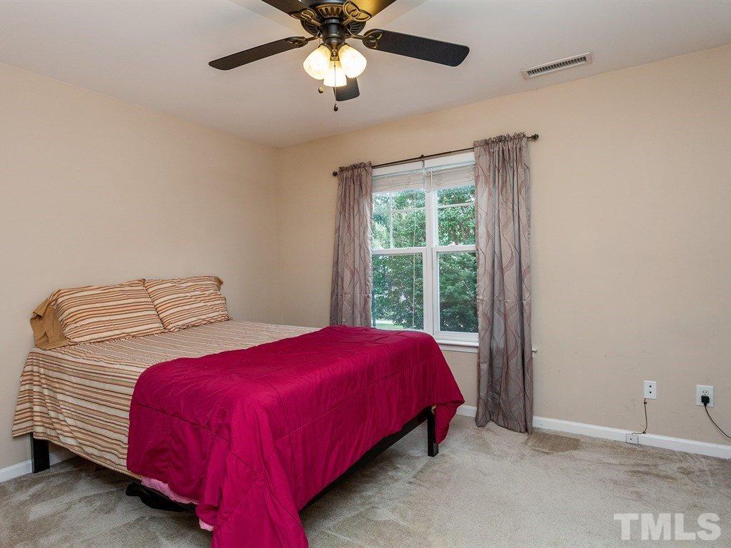 6621 Morgantown Street Raleigh, NC 27616 - Photo 20 of 25 a bedroom with a bed and a chandelier