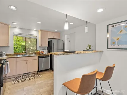 a kitchen with stainless steel appliances kitchen island granite countertop a sink and cabinets