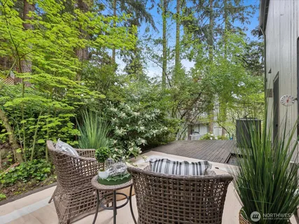 a view of a white house with large windows and plants