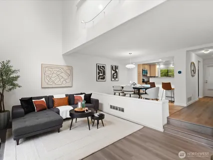 a living room with furniture and a dining table with wooden floor