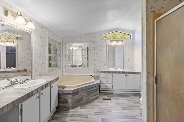 a bathroom with a tub sink and mirror
