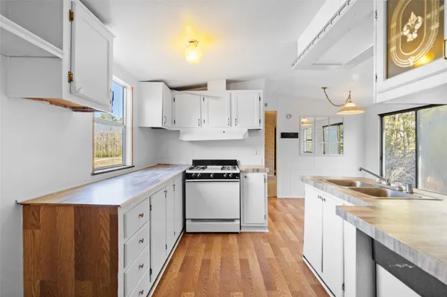 a kitchen with kitchen island granite countertop a sink stove and refrigerator