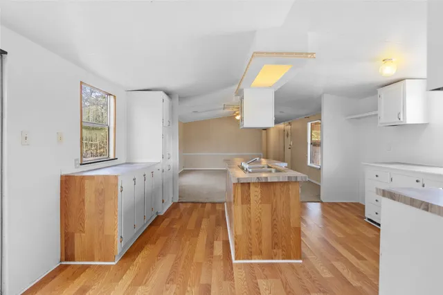 a kitchen with a sink and wooden floor