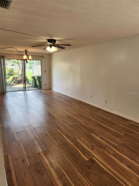 3773 Delta Street Sarasota, FL 34232 - Photo 5 of 15 an empty room with wooden floor chandelier and windows