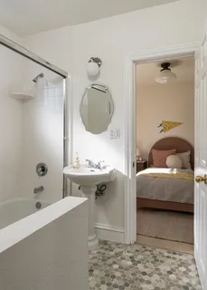 a bathroom with a tub sink and mirror