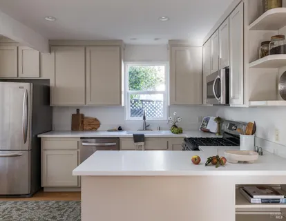 a kitchen with stainless steel appliances a sink a stove a refrigerator and cabinets