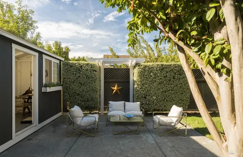 a view of patio with a table and chairs and potted plants