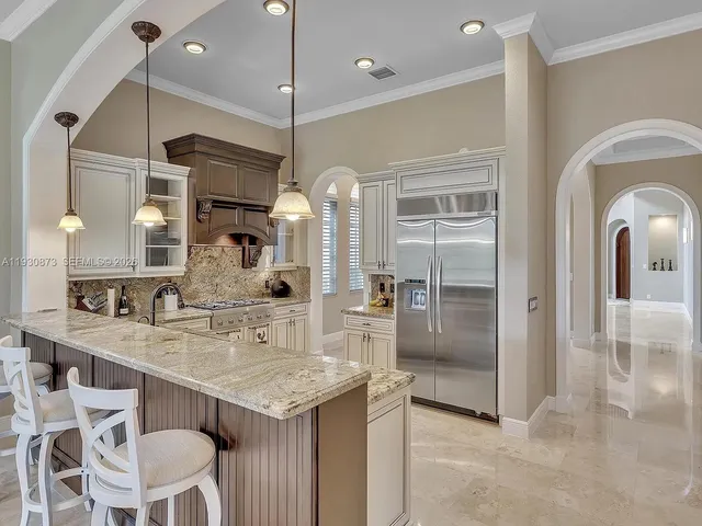 a kitchen with granite countertop a refrigerator and a sink