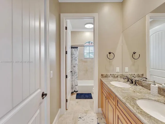 a bathroom with a granite countertop toilet sink and mirror