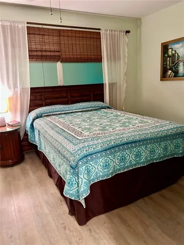 a view of a bedroom with wooden floor and closet