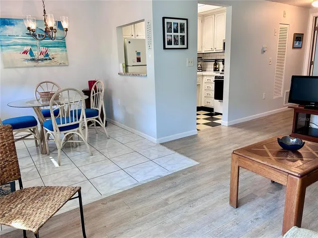 a living room with furniture a flat screen tv and kitchen view