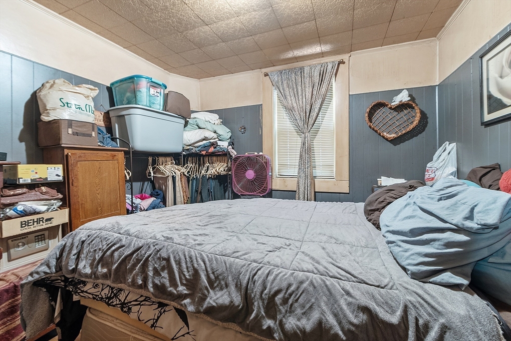 132 Hazel Street Fitchburg, MA 01420 - Photo 18 of 26 a bedroom with a bed and dresser with chair