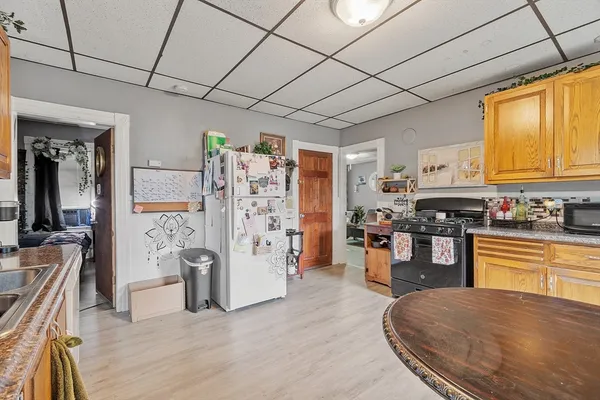 a kitchen with stainless steel appliances granite countertop a refrigerator a stove top oven a sink dishwasher and wooden cabinets