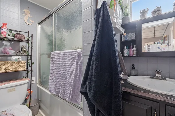 a bathroom with a granite countertop sink a toilet and shower