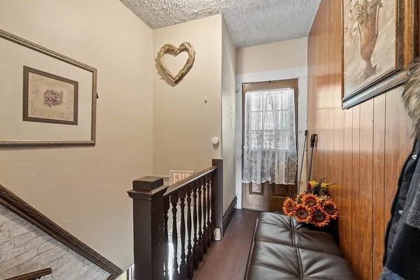 a view of a hallway with wooden floor and a chandelier