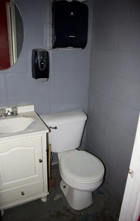 a white toilet sitting next to a white sink and vanity