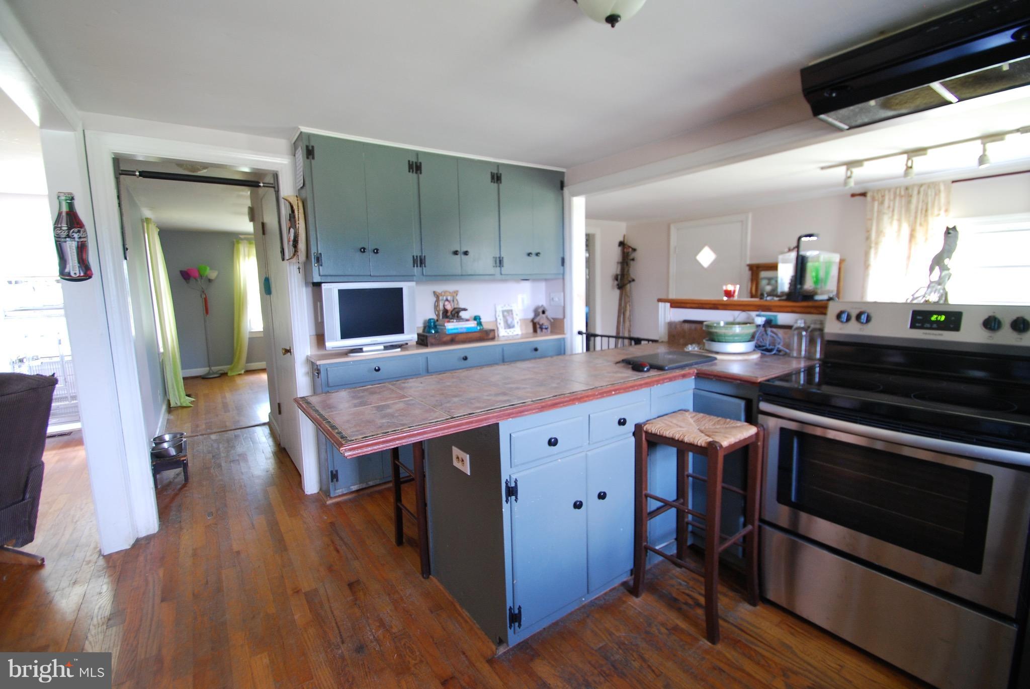 10775 Cliff Mills Road Marshall, VA 20115 - Photo 4 of 17 a kitchen with kitchen island wooden floors stove and sink