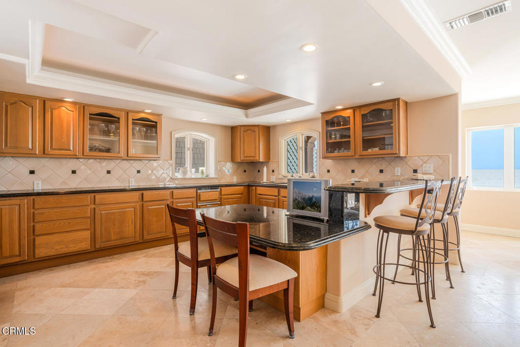 4165 Ocean Drive Oxnard, CA 93035 - Photo 11 of 44 a dining area with stainless steel appliances kitchen island granite countertop a table and chairs