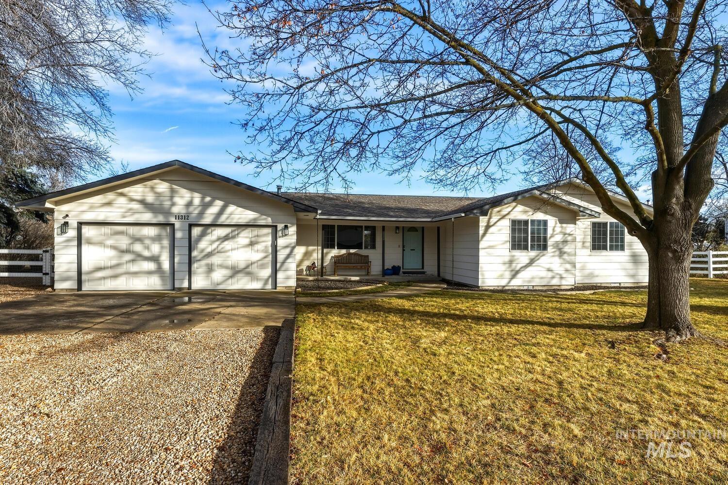 11312 West Highlander Road Boise, ID 83709 - Photo 1 of 1 Ranch-style house featuring concrete driveway, an attached garage, and covered porch