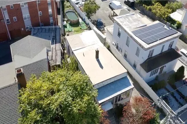 a view of a house with a small yard and wooden floor and fence