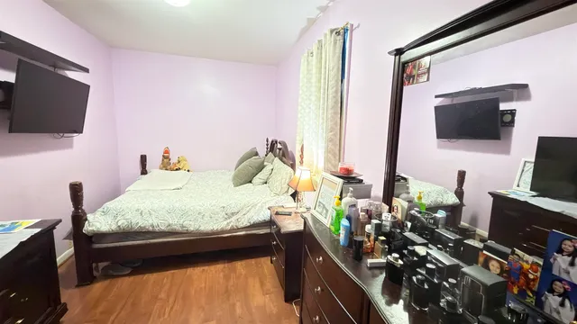 a bedroom with a bed window and flat screen tv