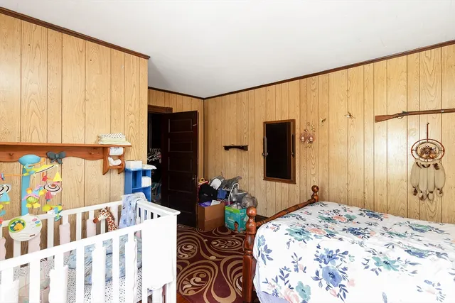 a bedroom with a bed a window and potted plant