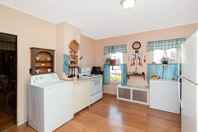a kitchen that has a lot of cabinets and wooden floor