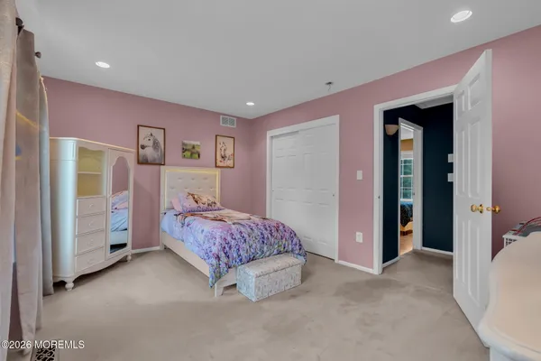 a spacious bedroom with a bed and a dresser