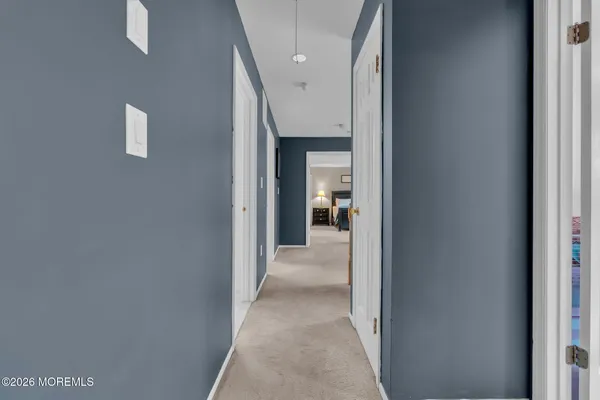 a view of a hallway with a livingroom and a bathroom with sink