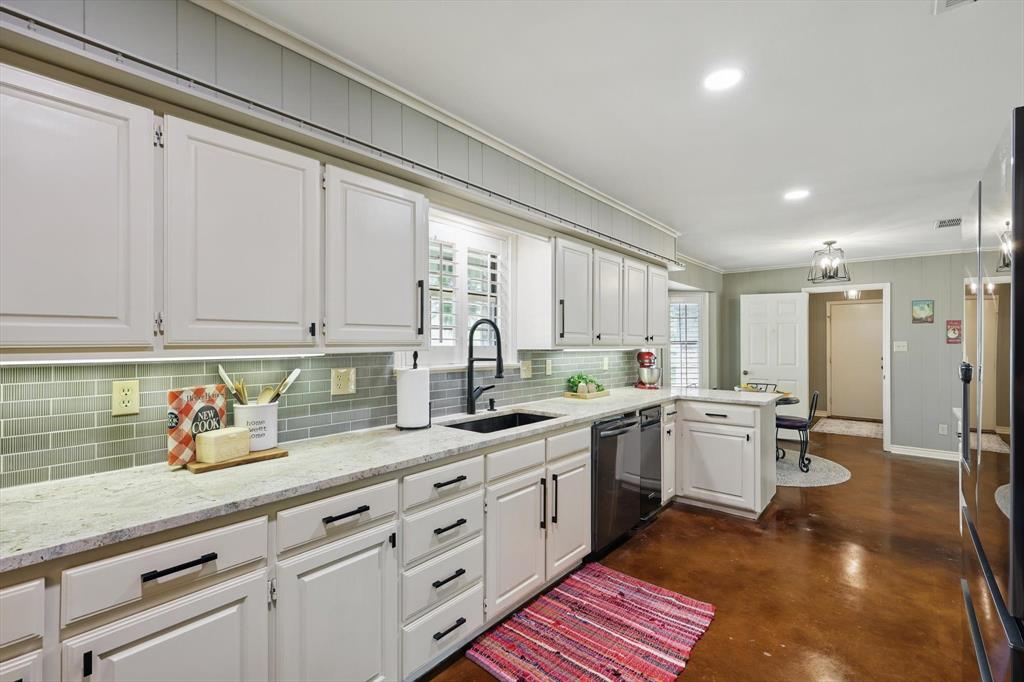 1904 Oak Ridge Trail Bridgeport, TX 76426 - Photo 12 of 34 Kitchen featuring crown molding, white cabinets, light stone counters, concrete flooring, and a peninsula