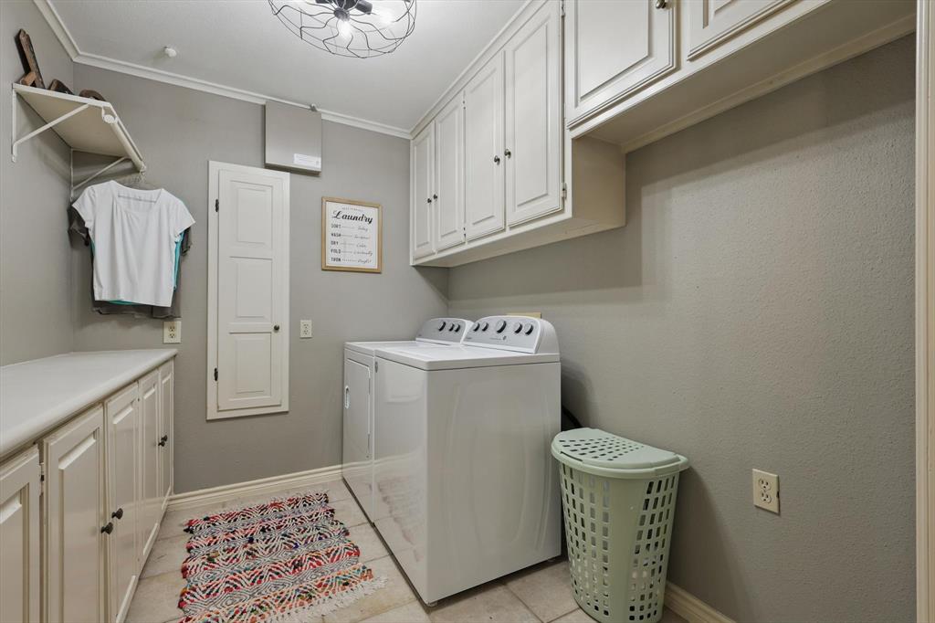 1904 Oak Ridge Trail Bridgeport, TX 76426 - Photo 14 of 34 Laundry area with cabinet space, independent washer and dryer, ornamental molding, and light tile patterned flooring