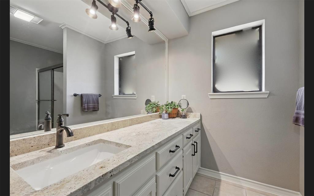 1904 Oak Ridge Trail Bridgeport, TX 76426 - Photo 24 of 34 Bathroom with vanity, ornamental molding, a stall shower, and light tile patterned floors